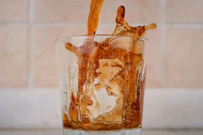 Close-up of a brown liquid splash captured in motion inside a clear glass.